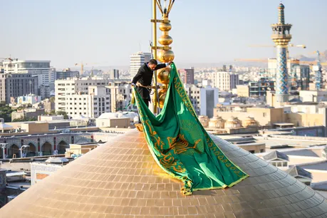 تعویض پرچم گنبد حرم مطهر رضوی