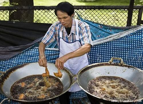 آشپزی که انگشتانش را با غذا سرخ می کند +عکس