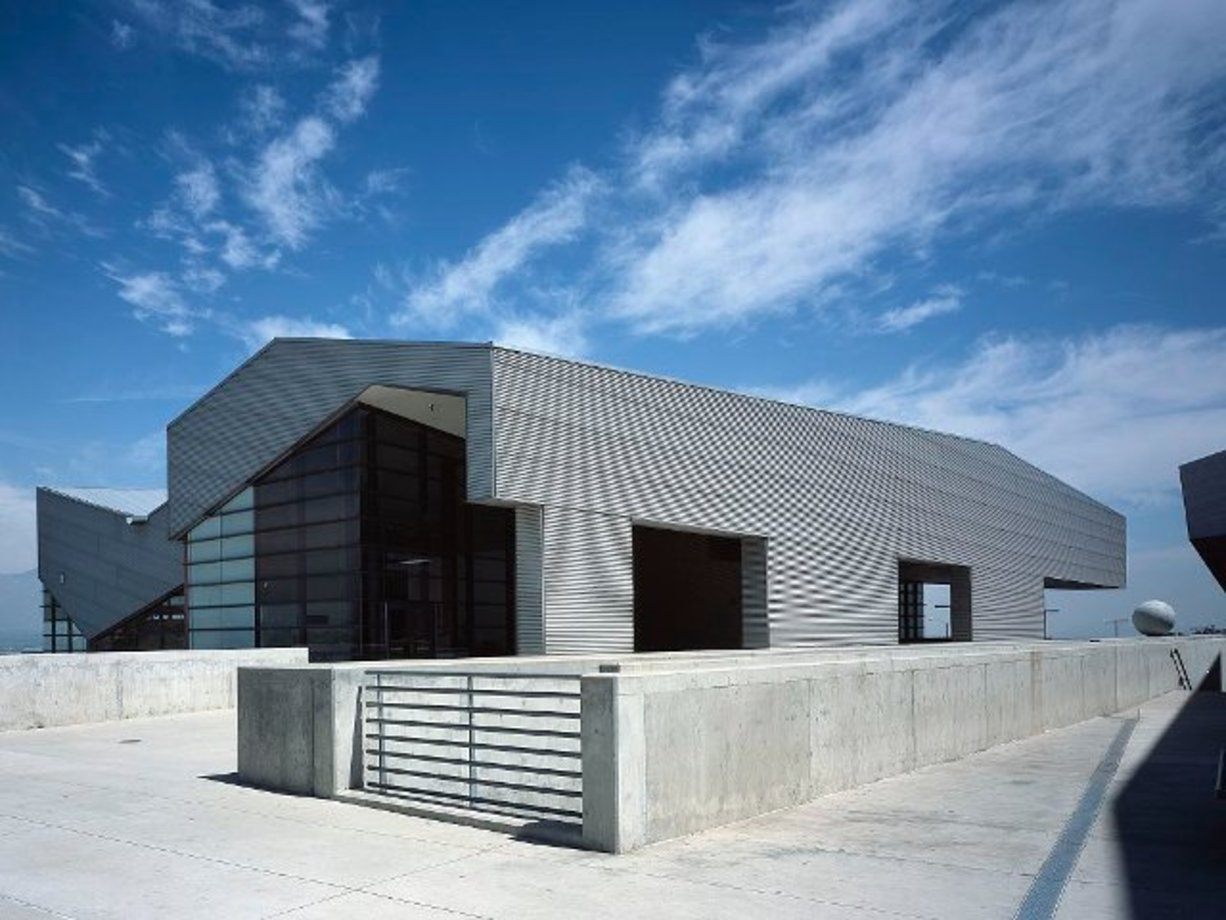دبیرستان Diamond Ranch در پومونا کالیفرنیا: این ساختمان بر روی یک تپه ساخته شده که معماران در ابتدا بر این باور بودند که این امر تقریبا غیرممکن است. 
ساختمان‌های دانشکده هنرهای نمایشی رامون کورتینز که مانند اهرام نامنظم شکل گرفته است. این مدرسه در محله چینی‌ها در لس آنجلس کالیفرنیا ساخته شده است.

عنصر منحنی و مارپیچی که در اطراف بالای یکی از ساختمان‌های آن پیچیده شده، بخشی از نشانه‌های طراحی آن است.