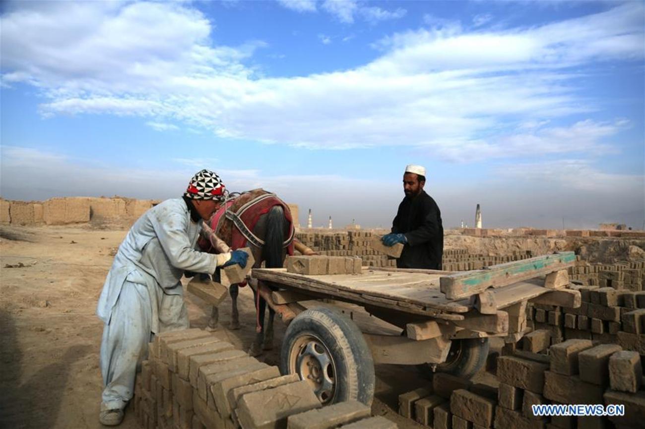 مردان افغان در حال بار زدن آجر در کوره آجرپزی در کابل افغانستان